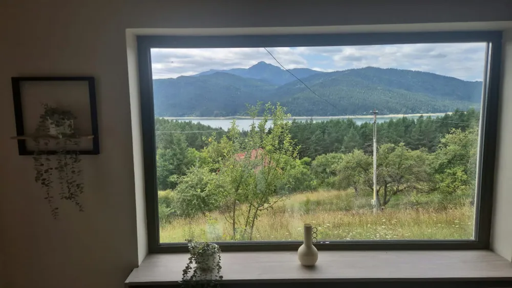 Vedere spectaculoasă lac și munți din fereastră